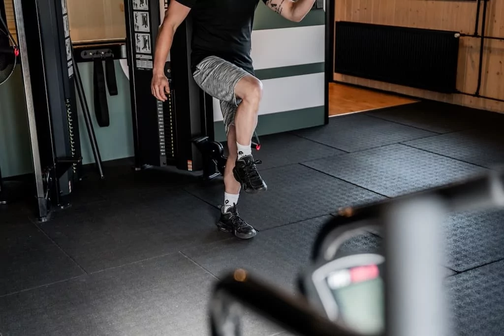 Man voert een balans- en coördinatieoefening uit in de fitnessruimte van Quality Lifestyle Training.